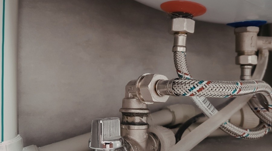 Plumbing maintenance: close-up of pipes and valves under sink